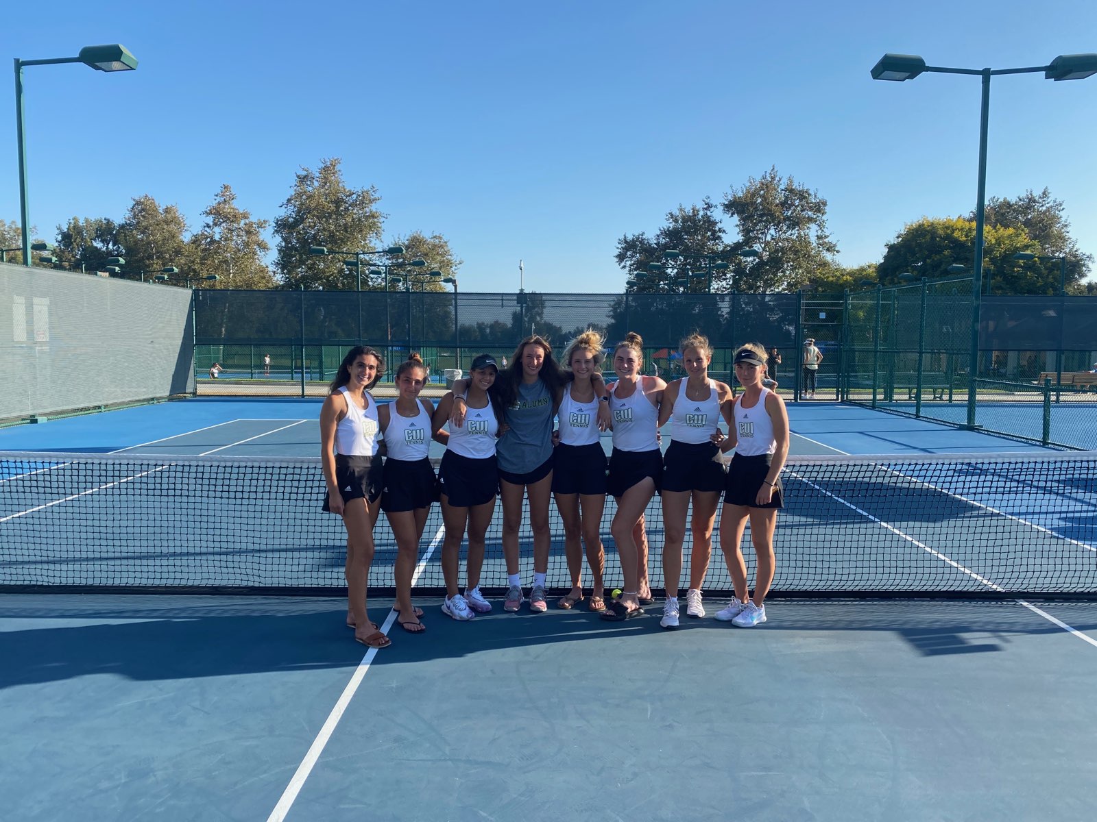 The women’s team poses after a practice at the tennis courts.